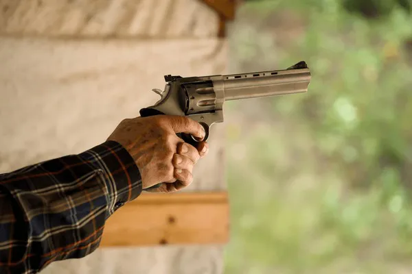 hands-firing-pistol-golden-shell-600nw-2656301395